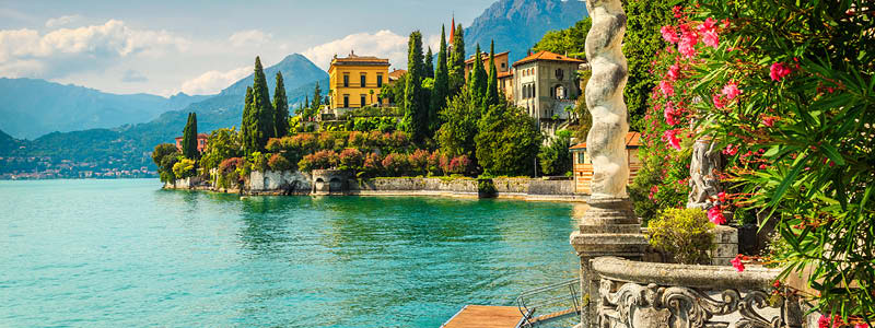 Statyer, blommor och neoklassiska villor vid Comosjön i Italien.